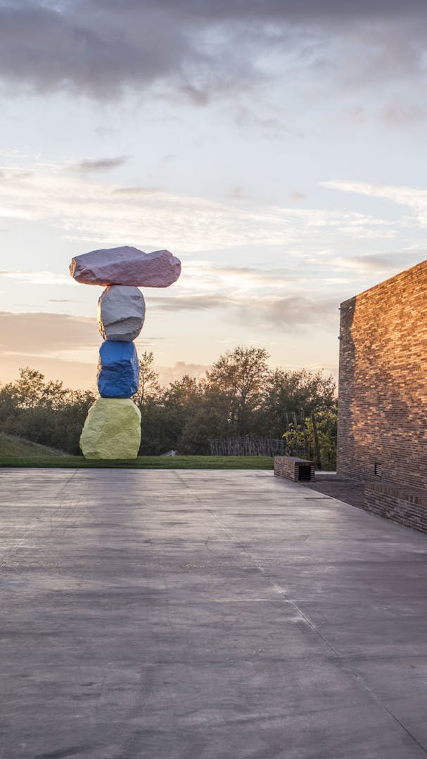 View of the winery made of bricks at sunset with sculture of Ugo Rondinone